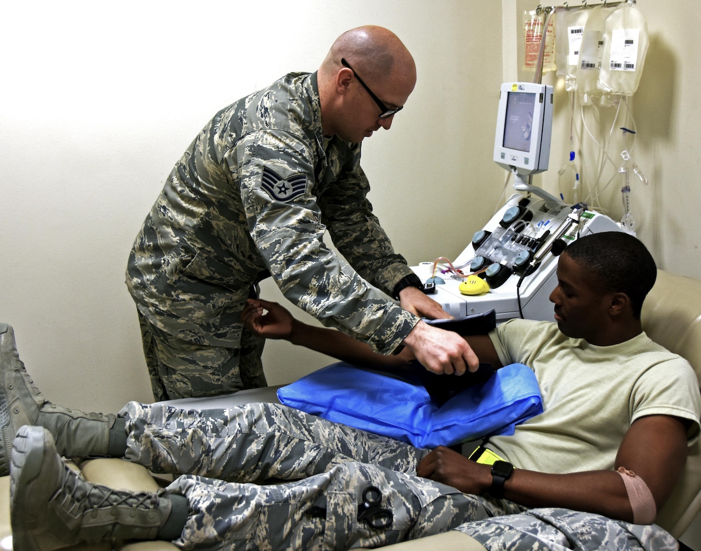 Staff Sgt. Jonathan Flannigan, NCO in charge of the apheresis element with the 379th Expeditionary Medical Group, wraps a pressure cuff around the arm of Senior Airman Jordan Marshall, an aerospace medical technician with the 379th EMDG, at Al Udeid Air Base, Qatar, March 7, 2017. Marshall volunteered to donate blood platelets which are essential to Airmen in combat zones without access to immediate medical treatment.  (U.S. Air Force photo by Senior Airman Cynthia A. Innocenti)