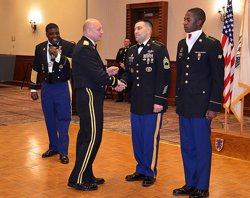 U.S. Army Maj. Gen. Anthony Funkhouser, Center for Initial Military Training commander, congratulates two newly promoted Soldiers assigned to the 7th Transportation Brigade (Expeditionary) during the Resolute Ball in Newport News, Va., March 2, 2017. During the event, Funkhouser also recognized other significant achievements throughout the brigade. (U.S Army photo/Staff Sgt. Miguel Bracero)