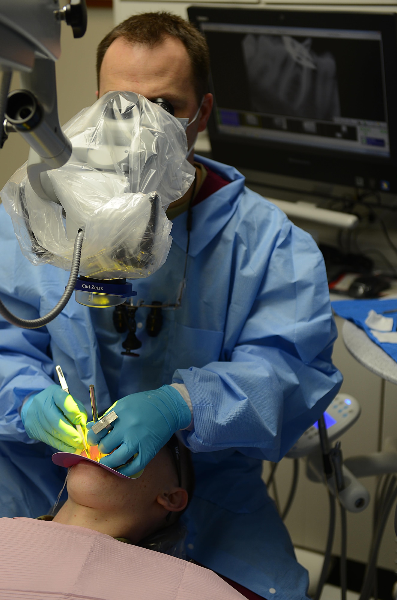 U.S. Army Maj. Bryan Horspool, U.S. Army Dental Command endodontist, examines a patient’s mouth during a procedure at the Tignor Dental Clinic at Joint Base Langley-Eustis, Va., March 10, 2017. During appointments, dentists use 3-D, panoramic and microscopes to view details in patients’ mouths that are not visible to the naked eye. (U.S. Air Force photo/Staff Sgt. Teresa J. Cleveland)