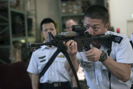 Members of the Japan Air Self-Defense Force learn about and handle different weapons during a tour of the Security Forces Squadron at Kadena Air Base, Japan, Mar. 14, 2017. They were then given a tour of the Squadron and its different sections, such as the base defense operations center, investigations office and interview and holding cells.