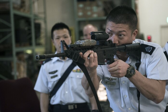 Members of the Japan Air Self-Defense Force learn about and handle different weapons during a tour of the Security Forces Squadron at Kadena Air Base, Japan, Mar. 14, 2017. They were then given a tour of the Squadron and its different sections, such as the base defense operations center, investigations office and interview and holding cells.