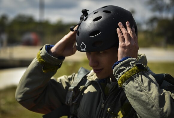 An Air Commando puts on his helmet during water survival training at Hurlburt Field, Fla., March 14, 2017. Water survival training is required for aircrew tri-annually to maintain proficiency on skill sets such as canopy disentanglement, parachute drop and drag, and life raft boarding. (U.S. Air Force photo by Airman 1st Class Joseph Pick)