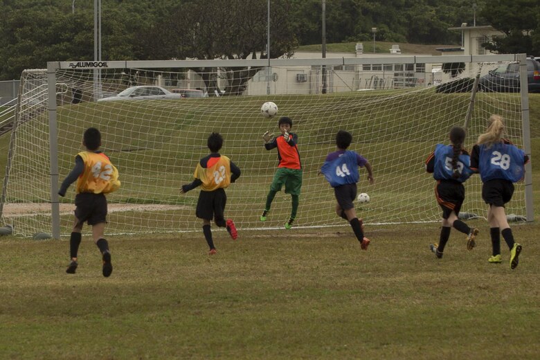 A goal keeper makes a save during the Marine Corps Community Services’ Friendship Soccer Game March 11 aboard Camp Foster, Okinawa, Japan. Yomitan Elementary School’s soccer team and Marine Corps Community Services’ soccer team, The Bandits, came together for this event. They played evenly mixed into two teams, and each team had an English and a Japanese speaking coach to help bridge the language gap. 