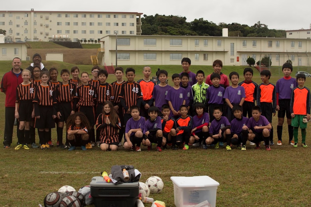 Players of the Yomitan Elementary School’s soccer team and Marine Corps Community Services’ soccer team, The Bandits, and their coaches pose for a group photo after the Marine Corps Community Services’ Friendship Soccer Game March 11 aboard Camp Foster, Okinawa, Japan. The two teams came together for a fun filled game of soccer. “We would love to come play every day if it were possible,” said Uechi Katsutoshi, coach of the Yomitan elementary school team. 
