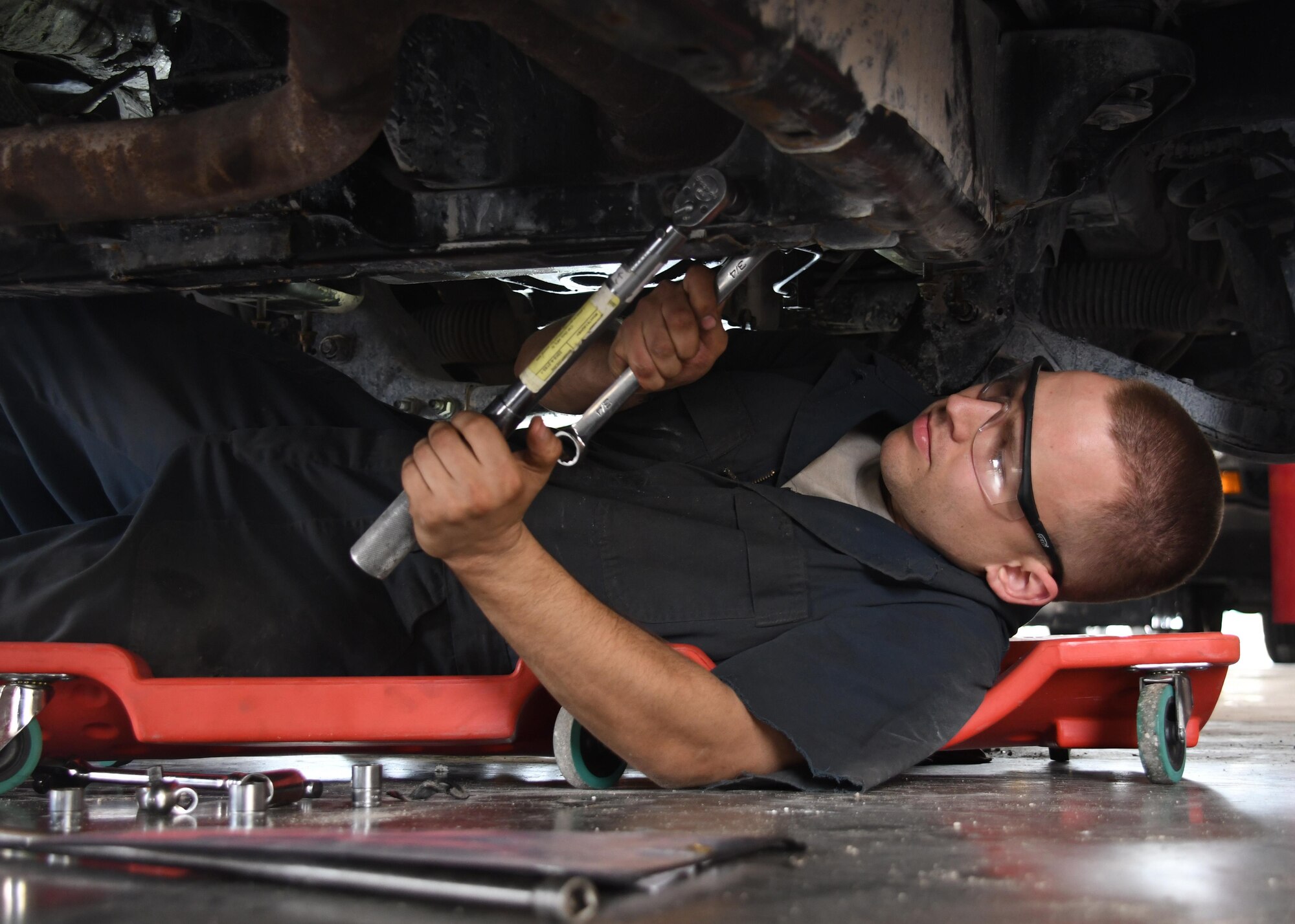 U.S. Air Force Senior Airman Nicholas Ramey, a light maintenance shop mechanic with the 379th Expeditionary Logistics Readiness Squadron Vehicle Management Flight, reattaches the exhaust pipe on a vehicle at Al Udeid Air Base, Qatar, March 11, 2017. When lease and government vehicles break down at Al Udeid, the Airmen of the vehicle management flight are responsible for troubleshooting and repairing them. (U.S. Air Force photo by Senior Airman Miles Wilson)