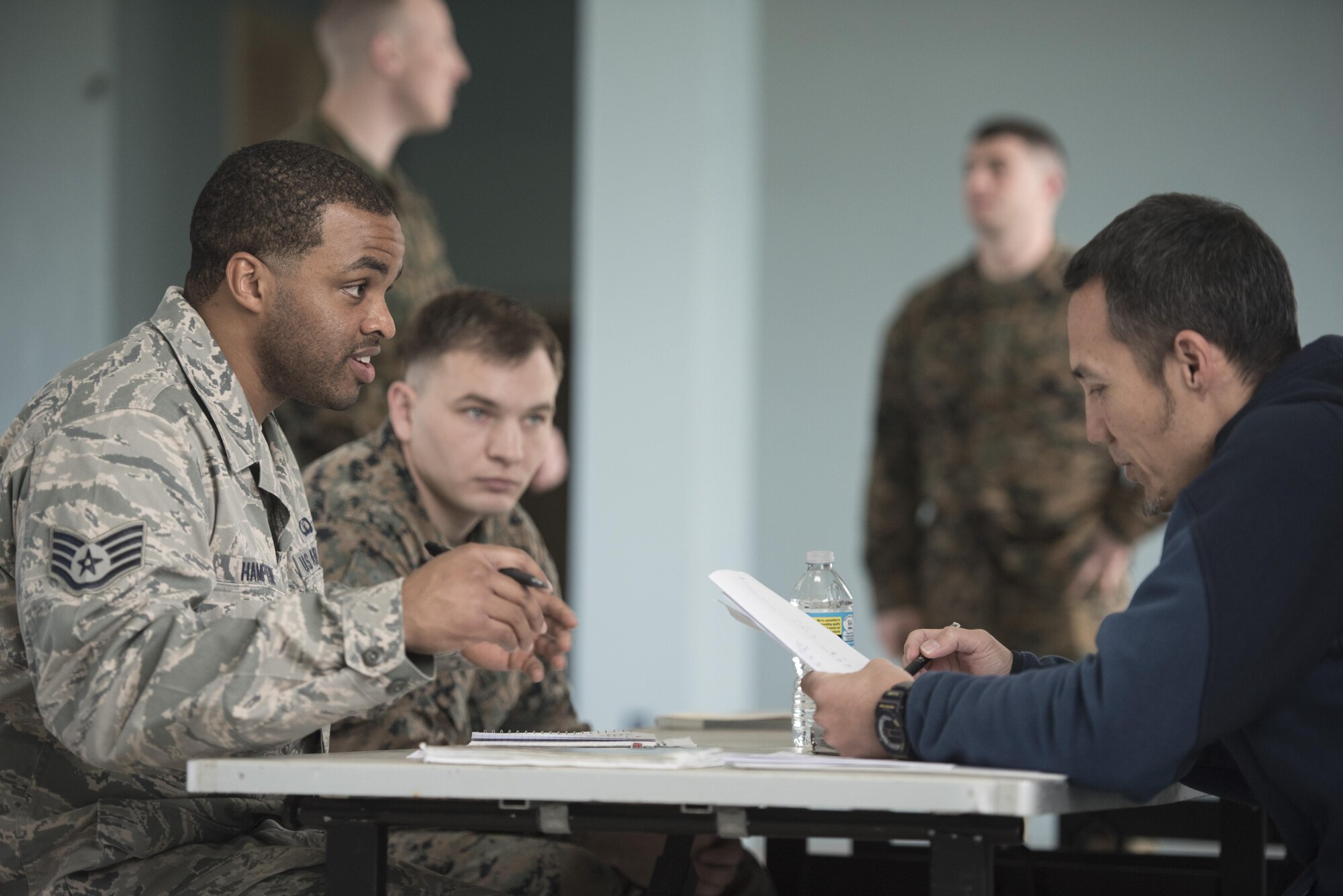 U.S. Air Force Staff Sgt. Lewis Hampton and Nichalos Apsens, 18th Contracting Squadron contracting officers, portray the roles of a contracting officer and a vendor during an operational contracting support joint exercise Jan. 24, 2017, at Camp Foster, Japan. In this scenario, contractors met with vendors, figured out how to communicate in Japanese without translators and negotiated contracts within 24-hours. (U.S. Air Force photo by Senior Airman Omari Bernard)