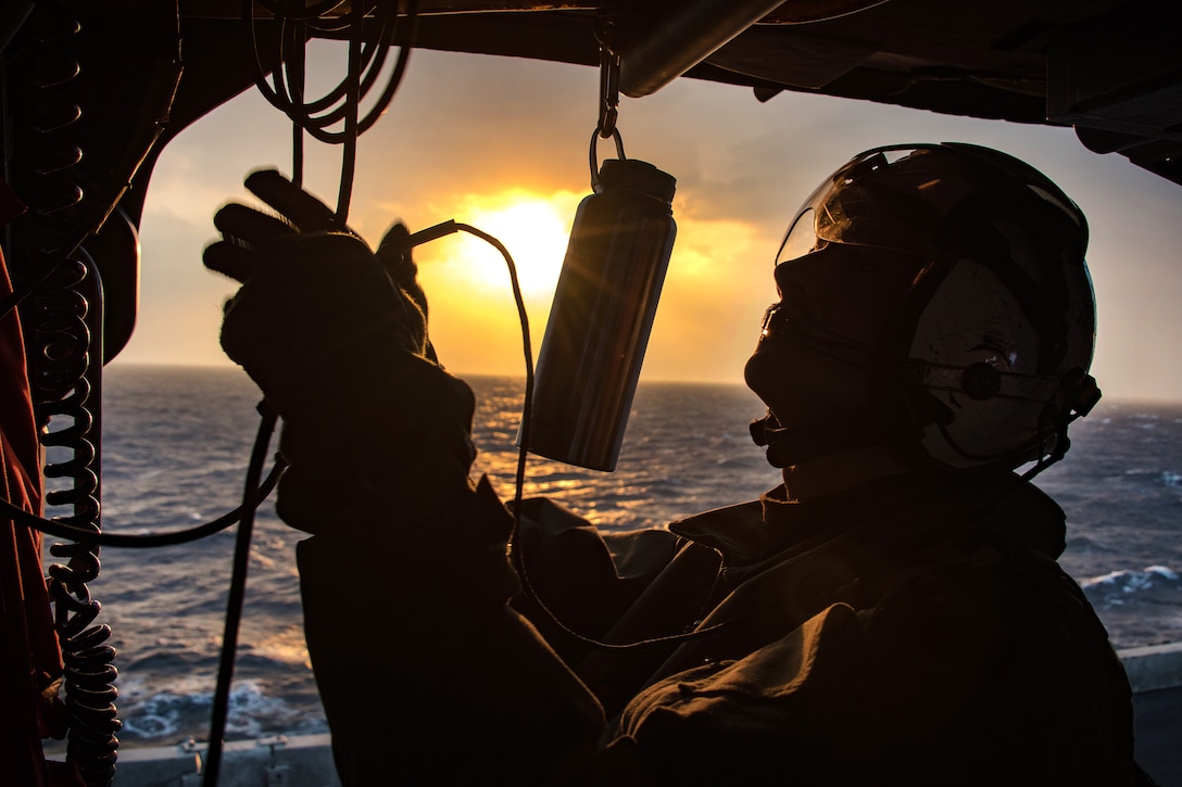 Navy Petty Officer 2nd Class Brendan Hutchins makes preparations to take off in an MH-60S Sea Hawk helicopter aboard the aircraft carrier USS Carl Vinson in the East China Sea, March 9, 2017. Hutchins is a naval helicopter aircrewman. Navy photo by Petty Officer 2nd Class Sean M. Castellano 