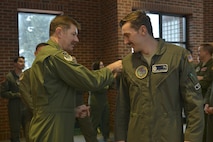 Lt. Col. Jonathan Austin, 91st Operations Group deputy commander, presents a 48-hour alert pin to 2nd Lt. Gregory Copeland, 742nd Missile Squadron deputy combat crew commander, at Minot Air Force Base, N.D., March 15, 2017. On March 6, a winter storm caused 91st Missile Wing Intercontinental Ballistic Missile operators to stay an extra night until a crew could safely replace them. (U.S. Air Force photo/Airman 1st Class Jessica Weissman)