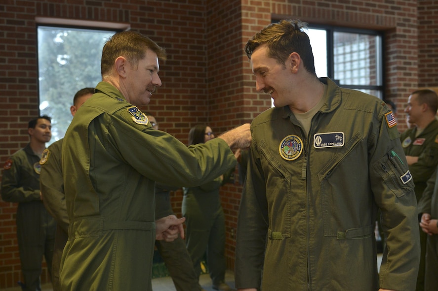 Lt. Col. Jonathan Austin, 91st Operations Group deputy commander, presents a 48-hour alert pin to 2nd Lt. Gregory Copeland, 742nd Missile Squadron deputy combat crew commander, at Minot Air Force Base, N.D., March 15, 2017. On March 6, a winter storm caused 91st Missile Wing Intercontinental Ballistic Missile operators to stay an extra night until a crew could safely replace them. (U.S. Air Force photo/Airman 1st Class Jessica Weissman)