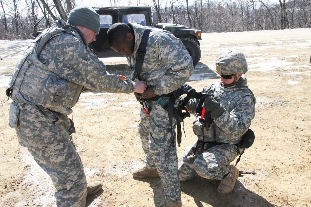 FORT MCCOY, Wis. - U.S. Army Reserve Soldiers with 327th Engineer Company, 416th Theater Engineer Command, assist another 327th Eng. Co. Soldier with his gunners harness prior to completing the blank-fire range during Operation Cold Steel at McCoy, Wis., March 13, 2017. Operation Cold Steel is the U.S. Army Reserve's crew-served weapons qualification and validation exercise to ensure that America's Army Reserve units and soldiers are trained and ready to deploy on short-notice and bring combat-ready and lethal firepower in support of the Army and our joint partners anywhere in the world. (U.S. Army Reserve photo by Staff Sgt. Debralee Best, 84th Training Command)