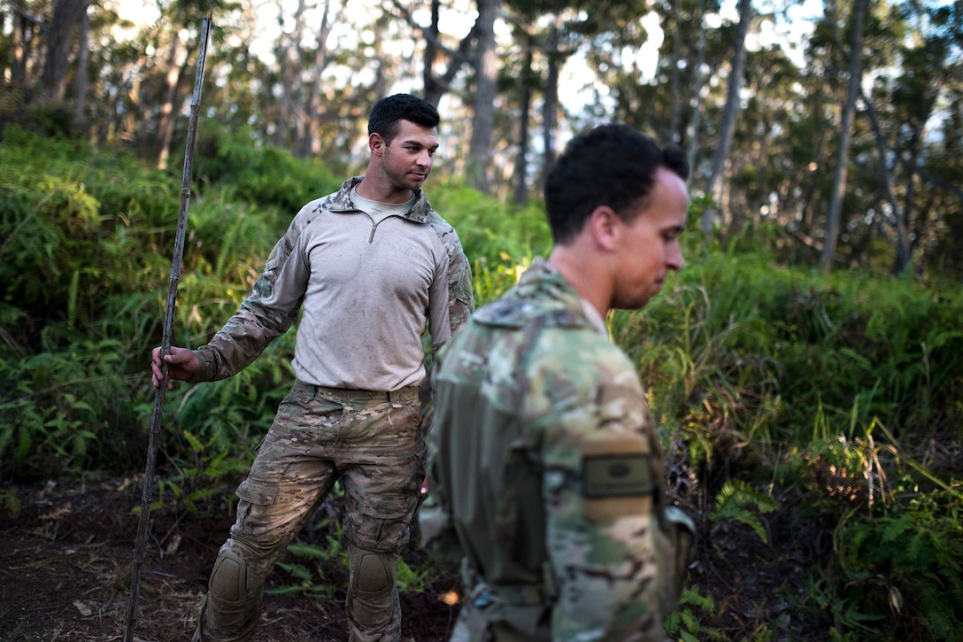 Air Force Senior Airmen Jonathan Harvey, foreground, and Alex Triani gather wood for a fire during survival training at the Army's Jungle Operations Training Course in Hawaii, March 7, 2017. Harvey and Triani are survival, evasion, resistance and escape specialist assigned to the 106th Rescue Wing. Air National Guard photo by Staff Sgt. Christopher S. Muncy
