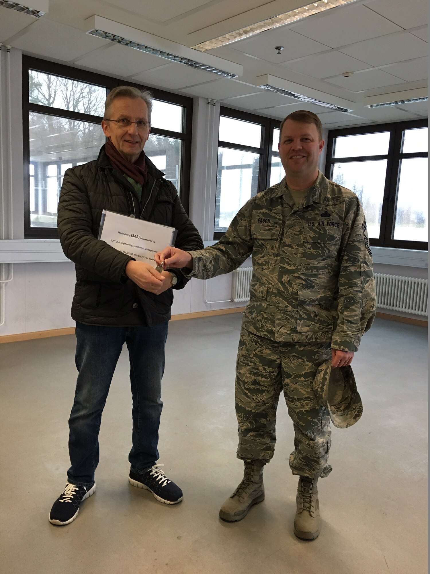 Chief Master Sgt. Jonathan Eason, former 606th Air Control Squadron chief enlisted manager Detachment 1, hands over the keys to building 345, the former location of the 606th ACS to Josef Ehlenz, 52nd Civil Engineer Squadron base property specialist, at Spangdahlem Air Base, Germany, March 8, 2017. (Courtesy photo)