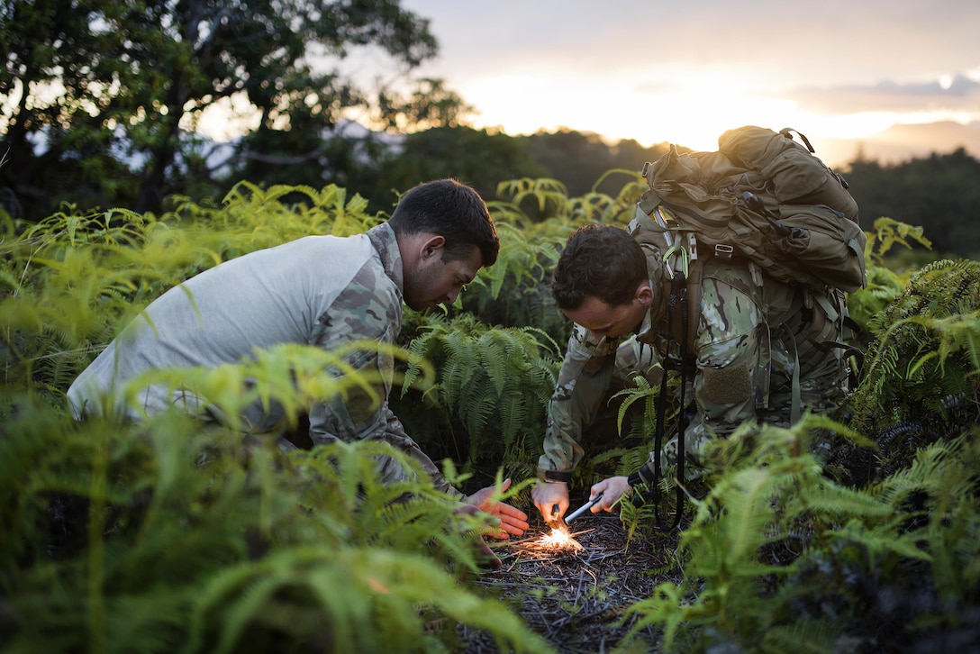 Air Force Senior Airmen Jonathan Harvey, right, and Alex Triani, start a fire during survival training at the Army's Jungle Operations Training Course in Hawaii, March 8, 2017. Harvey and Triani are survival, evasion, resistance and escape specialist assigned to the 106th Rescue Wing. Air National Guard photo by Staff Sgt. Christopher S. Muncy

