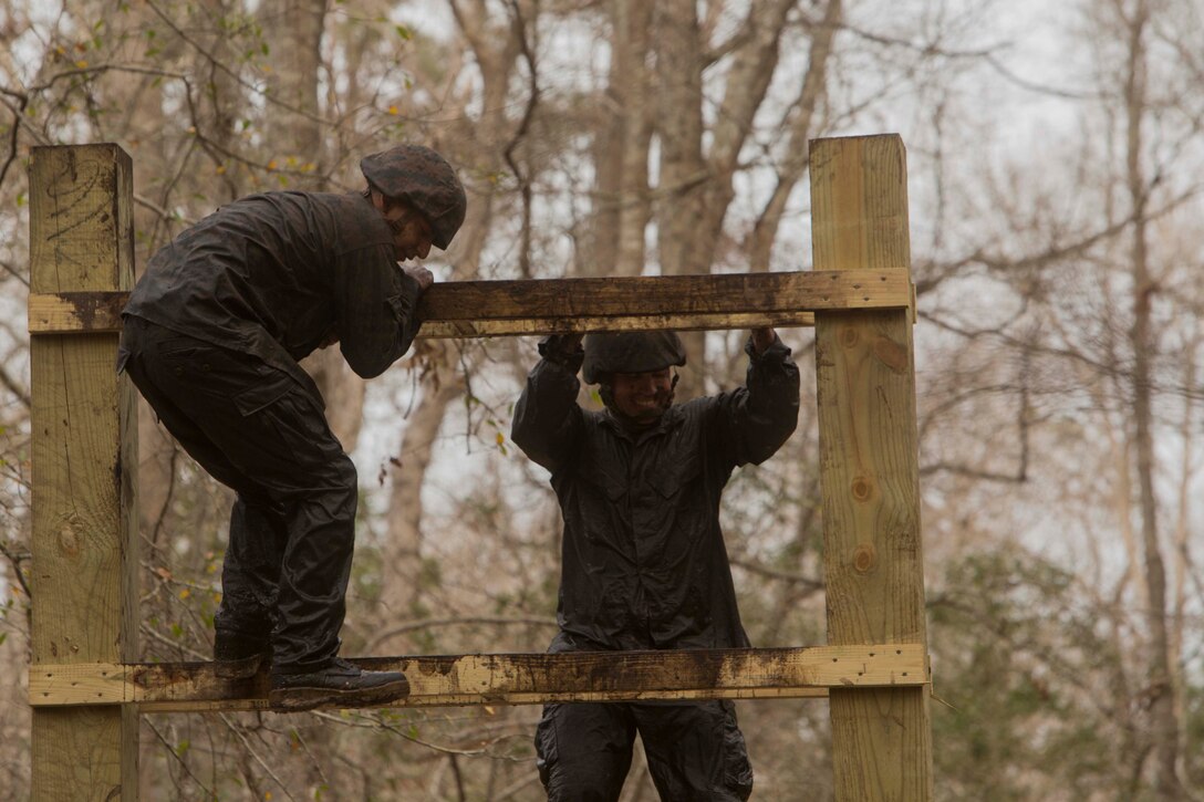 Marines climb over an obstacle during an endurance course at the Battle Skills Training School on Camp Lejeune, N.C., Mar. 10, 2017. The course is designed to improve and test Marines on their ability to work together through the challenging obstacles.  The Marines are with 8th Engineer Support Battalion. (U.S. Marine Corps photo by Pfc. Abrey Liggins)