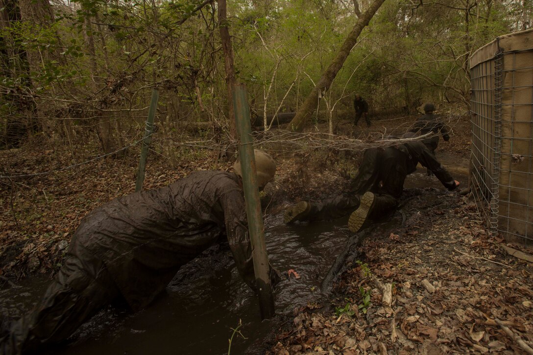 Marines crawl in muddy water during an endurance course at the Battle Skills Training School on Camp Lejeune, N.C., March. 10, 2017. The course is designed to improve and test Marines on their ability to work together through the challenging obstacles.  The Marines are with 8th Engineer Support Battalion. (U.S. Marine Corps photo by Pfc. Abrey Liggins)