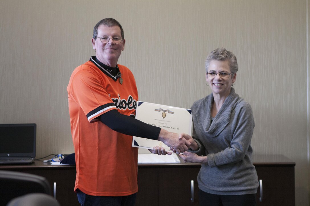 Scott Rosbaugh, director of DLA Distributions Future Plans directorate is presented the DLA Superior Civilian Service Award by Twila C. Gonzales, Senior Executive Service, DLA Distribution deputy commander on Mar. 3.