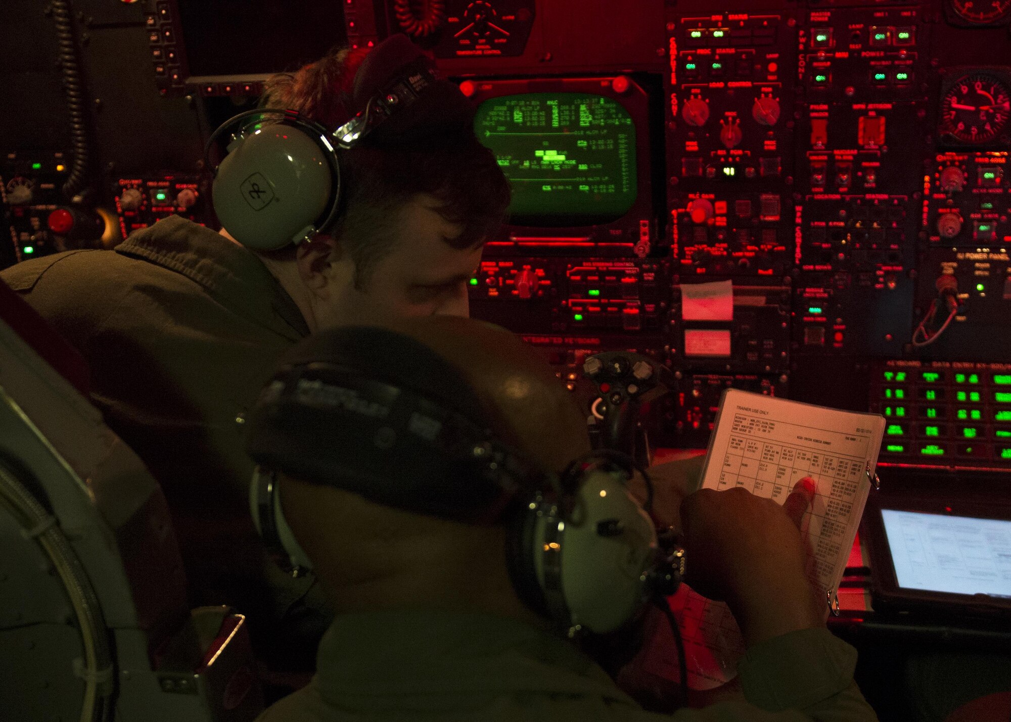Capt. Dino Johnson, 69th Bomb Squadron weapons system officer instructor, trains 1st Lt. Wade Waldmann, 69th BS weapons systems officer, on the controls of a B-52H Stratofortress during a simulated flight in the B-52 navigator simulator at Minot Air Force Base, N.D., March 8, 2017. The navigator simulator is located next to the B-52 weapons system trainer and allows aircrews to prepare for real world flight, emergencies and combat. (U.S. Air Force photo/Airman 1st Class Alyssa M. Akers)