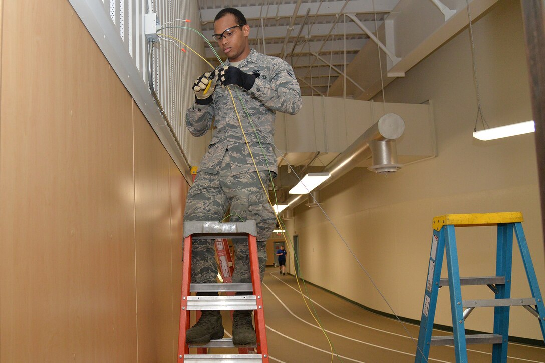 Airman 1st Class Kristoff Chin, 341st Civil Engineer Squadron electrical systems apprentice, replaces emergency lights in the fitness center March 13, 2017, at Malmstrom Air Force Base, Mont. The 341st Civil Engineer Squadron electrical shop will be replacing more than 12,000 fluorescent light fixtures with LED lamps at nine facilities on base. (U.S. Air Force photo/Airman 1st Class Daniel Brosam)