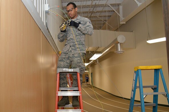 Airman 1st Class Kristoff Chin, 341st Civil Engineer Squadron electrical systems apprentice, replaces emergency lights in the fitness center March 13, 2017, at Malmstrom Air Force Base, Mont. The 341st Civil Engineer Squadron electrical shop will be replacing more than 12,000 fluorescent light fixtures with LED lamps at nine facilities on base. (U.S. Air Force photo/Airman 1st Class Daniel Brosam)