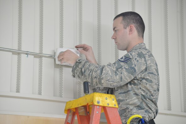 Staff Sgt. Joseph Gessert, 341st Civil Engineer Squadron electrical systems craftsmen, replaces emergency lights in the fitness center March 13, 2017, at Malmstrom Air Force Base, Mont. LED lights require half the wattage of currently used lights and also have a lamp life of 50,000 hours, nearly five times the life of fluorescent lights. (U.S. Air Force photo/Airman 1st Class Daniel Brosam)