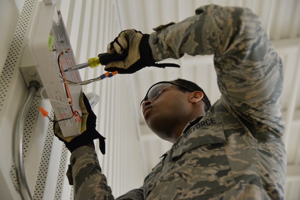 Airman 1st Class Kristoff Chin, 341st Civil Engineer Squadron electrical systems apprentice, fixes an emergency light in the fitness center March 13, 2017, at Malmstrom Air Force Base, Mont. The electrical team is replacing more than 12,000 lamps on base at nine facilities with LEDs, and they have already completed three of the nine buildings. (U.S. Air Force photo/Airman 1st Class Daniel Brosam)