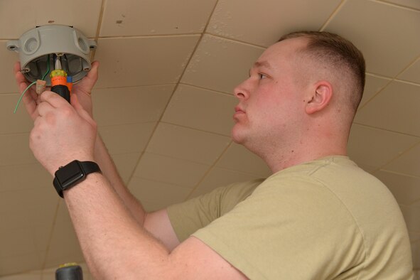 Senior Airman Dillon Halbach, 341st Civil Engineer Squadron electrical systems journeyman, repairs a light fixture inside the fitness center March 13, 2017, at Malmstrom Air Force Base, Mont. LED lights require half the wattage of currently used lights and also have a lamp life of 50,000 hours, nearly five times the life of fluorescent lights. (U.S. Air Force photo/Airman 1st Class Daniel Brosam)
