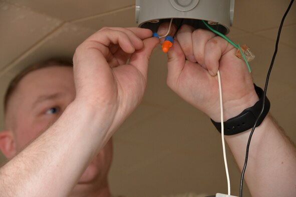 Senior Airman Dillon Halbach, 341st Civil Engineer Squadron electrical systems journeyman, repairs a light fixture inside the fitness center March 13, 2017, at Malmstrom Air Force Base, Mont. LED lights require half the wattage of currently used lights and also have a lamp life of 50,000 hours, nearly five times the life of fluorescent lights. (U.S. Air Force photo/Airman 1st Class Daniel Brosam)