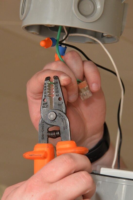 Senior Airman Dillon Halbach, 341st Civil Engineer Squadron electrical systems journeyman, repairs a light fixture inside the fitness center March 13, 2017, at Malmstrom Air Force Base, Mont. LED lights require half the wattage of currently used lights and also have a lamp life of 50,000 hours, nearly five times the life of fluorescent lights. (U.S. Air Force photo/Airman 1st Class Daniel Brosam)
