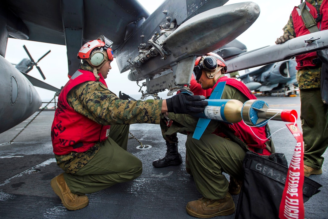 Marine Corps Cpl. Knickola Anaya, left, and Lance Cpl. Roberto Almanza load a laser guided training bomb onto an AV-8B Harrier in support of amphibious integration training aboard the amphibious assault ship USS Bonhomme Richard in the Philippine Sea, March 13, 2017. Anaya and Almanza are assigned to 31st Marine Expeditionary Unit. Navy photo by Petty Officer 3rd Class Jeanette Mullinax