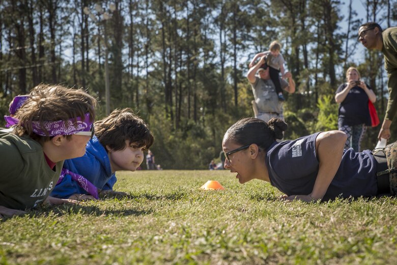 Sgt. Jasmine Smith encourages children during a modified Combat Fitness Test at Mini Marines aboard Marine Corps Air Station, Mar. 11. The event, hosted by Marine Corps Community Services Beaufort, to promote a camaraderie and a family atmosphere for Marines and their children. It also gives children a view into what their parents do at work. Smith is a training non-commissioned officer with Marine Aviation Logistics Squadron 31, Marine Aircraft Group 31.
