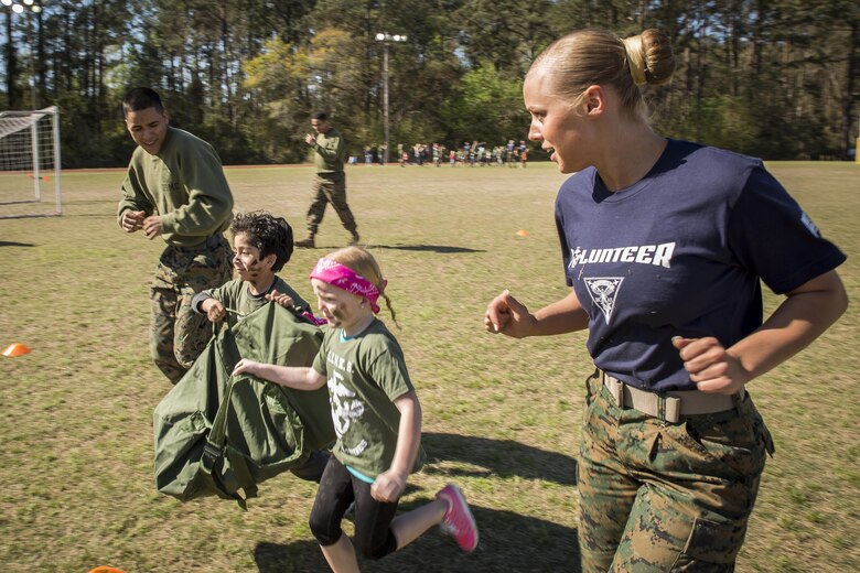Marines guide children through a modified Combat Fitness Test during Mini Marines aboard Marine Corps Air Station, Mar. 11. The Marine Corps Community Services event is held for families and children to show them what their parents do at work. The Marines are stationed aboard MCAS Beaufort.