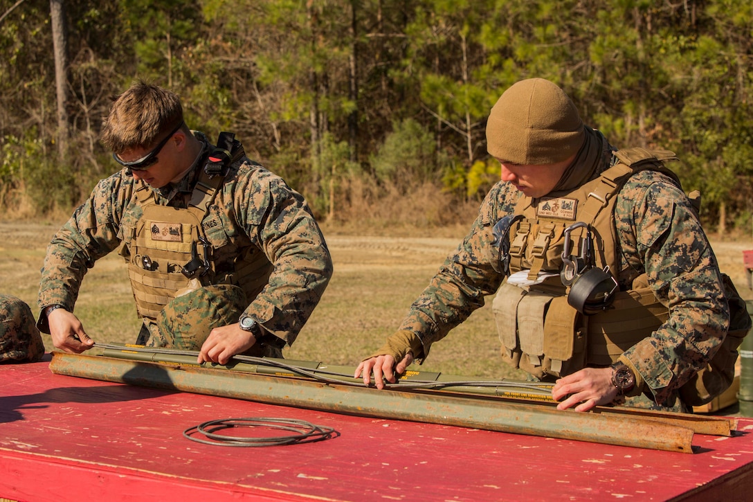 Marines attach detonation cords to an expedient Bangalore charge at Engineer Training Area 7 on Camp Lejeune, N.C., March 15, 2017. The Marines are undergoing basic demolitions training to increase proficiency and confidence with the employment of basic and expedient demolition charges. The Marines are with Combat Logistics Battalion 22, Headquarters Regiment. (U.S. Marine Corps photo by Pfc. Abrey Liggins)