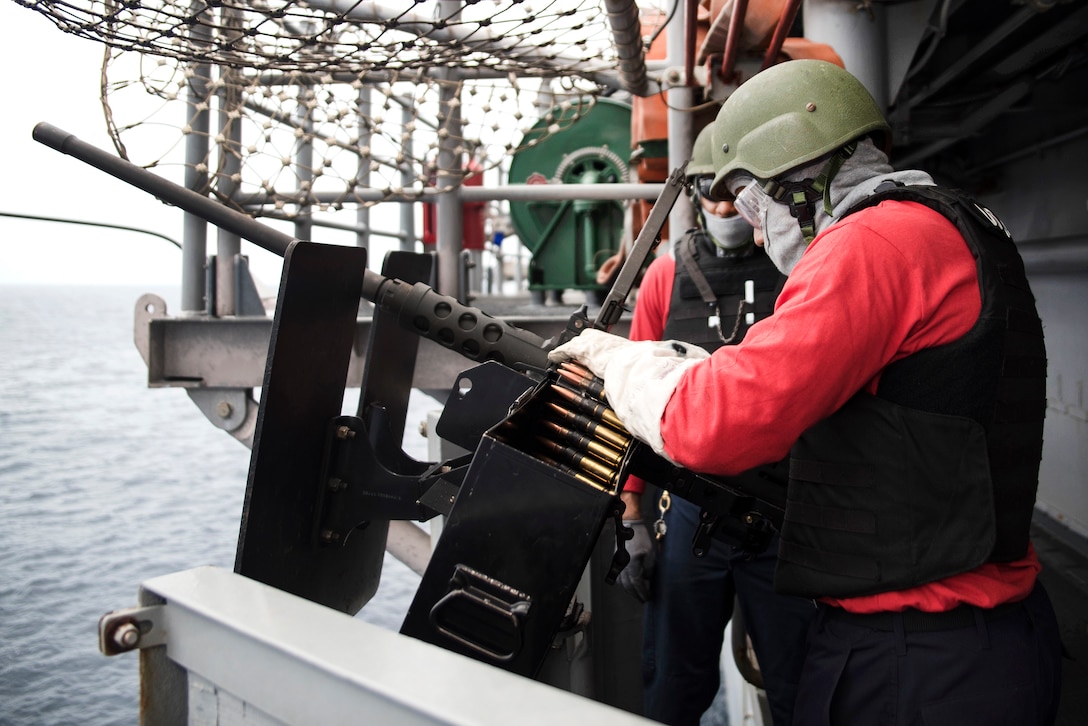 Navy Seaman Yusef Ali Reynolds, front, and Navy Petty Officer 2nd Class Christopher Womack load a .50-caliber machine gun during small craft action team training aboard amphibious assault ship USS Bonhomme Richard in the Philippine Sea, March 13, 2017. Reynolds and Womack are gunner’s mates. Navy photo by Seaman Jesse Marquez Magallanes