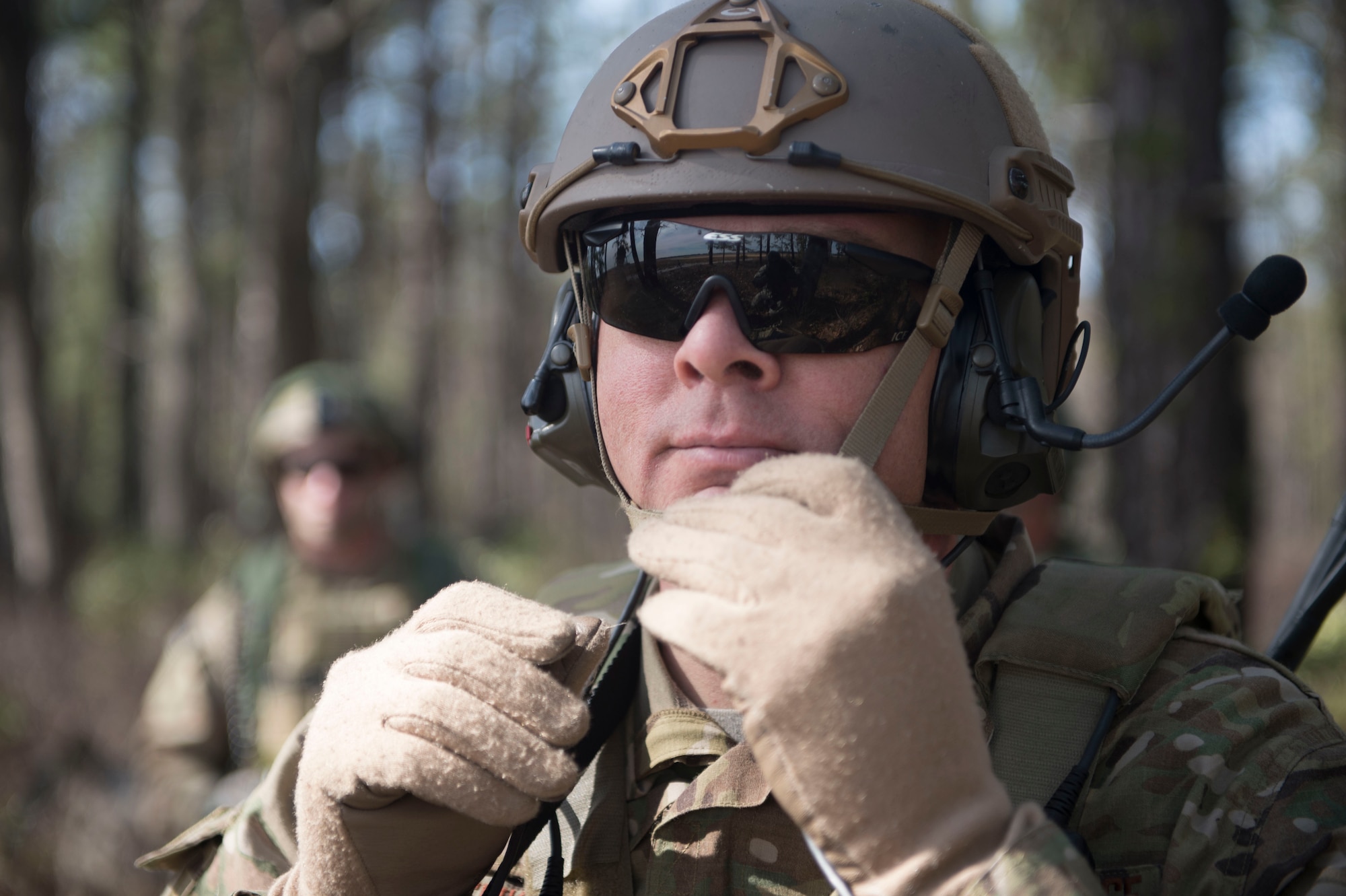 U.S. Air Force Maj. Ryan Schenk, 621st Mobility Support Operations Squadron air mobility liaison officer assigned to the 101st Airborne Division at Fort Campbell, Ky., adjusts his helmet while waiting for the airfield to be cleared during a mobility exercise called WAREX at Joint Base McGuire-Dix-Lakehurst, N.J., March 13, 2017. AMLOs are highly experienced, U.S. Air Force pilots and navagators embedded with Army and Marine units, in-garrison and deployed. (U.S. Air Force photo by Tech. Sgt. Gustavo Gonzalez/RELEASED)