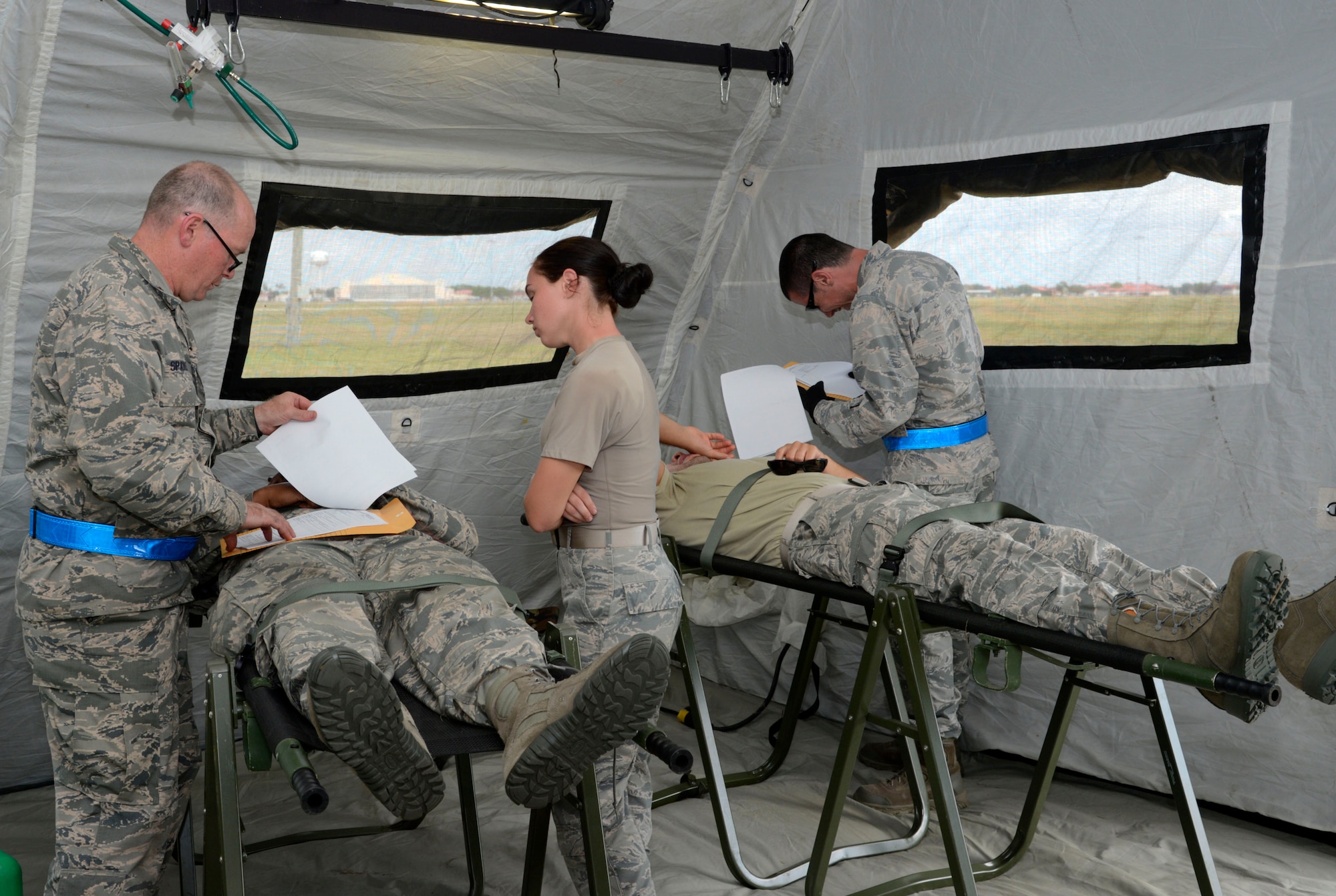 Two nurses and a medical technician provide patient care to simulated injuries during an aeromedical evacuation exercise at MacDill Air Force Base, Fla., March 12, 2017. As a role two staging facility, an En Route Patient Staging System team secures and stabilizes any first responder care done in the field while simultaneously preparing patients for travel to a more advanced form of care. (U.S. Air Force photo by Senior Airman Tori Schultz)