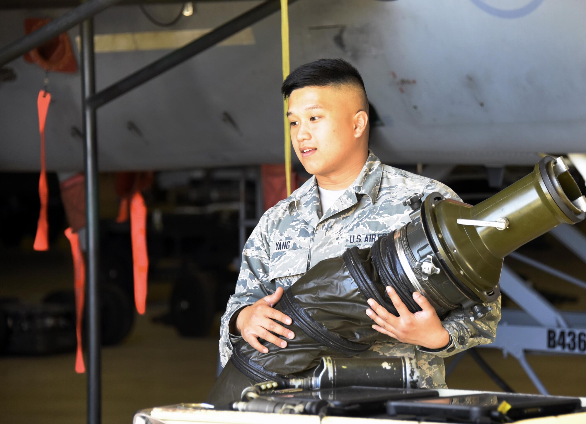 Airman 1st Class John Yang, 363rd Training Squadron aircraft armament student, attaches the cool air hose to an F-15 Eagle aircraft. To run external electronics, cool air is required. (U.S. Air Force photo by Liz H. Colunga/Released)