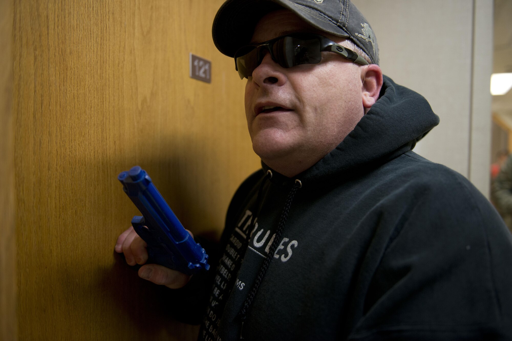 Air Force Master Sergeant Daniel Chrisco, an active shooter exercise player pretends to be a co-worker as he knocks on office doors in the 773d Civil Engineer Squadron in an attempt to get someone to open their door during an exercise March 13. The Security Forces Squadron on Joint Base Elmendorf-Richardson conducts regular no-notice tests of offices’ active shooter mentalities around base.