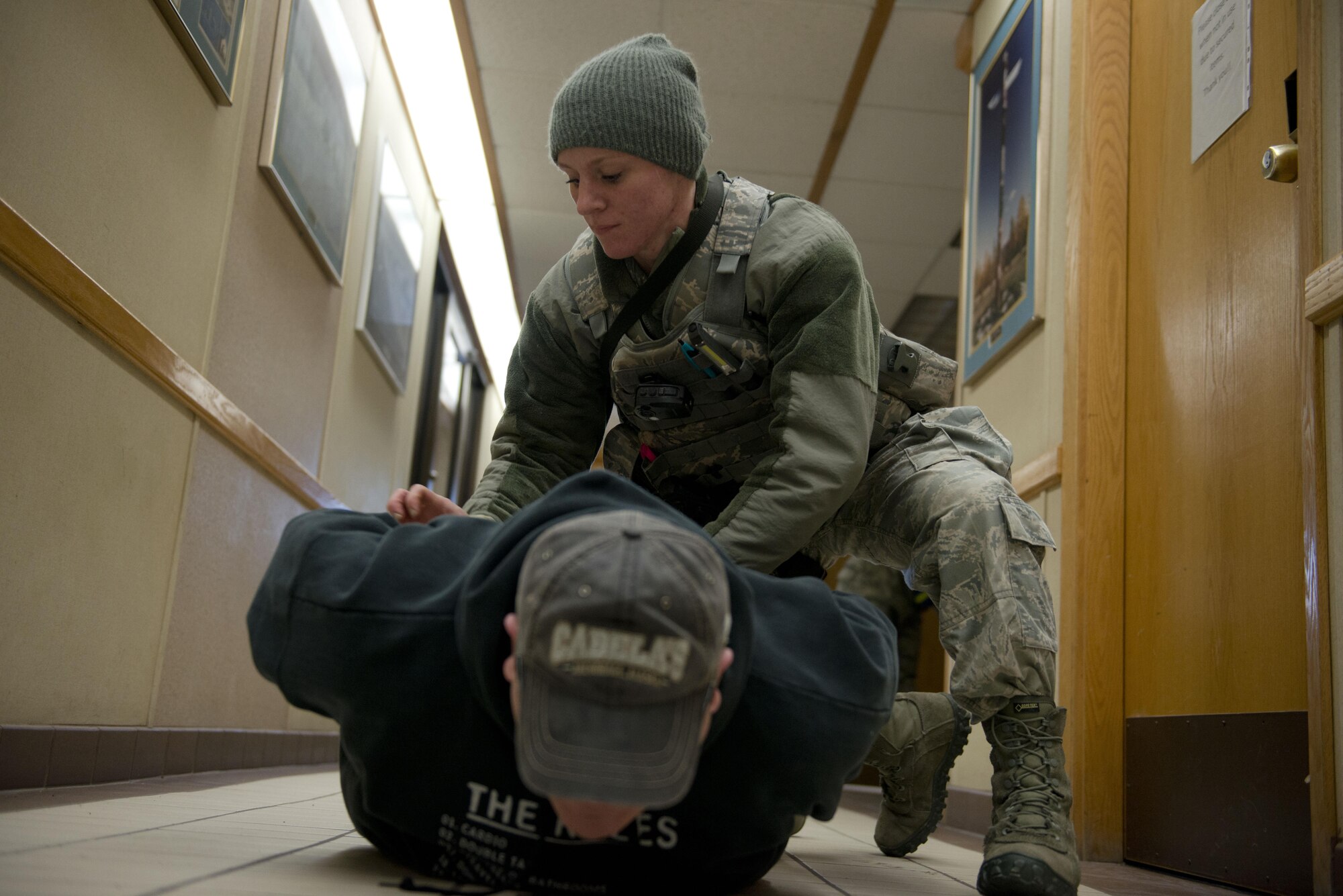 Air Force Staff Sgt. Brittney Howard, a patrolman with the 673d Security Forces Squadron pins down and detains Air Force Master Sgt. Daniel Chrisco, an active shooter exercise player, in the 773rd Civil Engineer Squadron, March 13. The Security Forces Squadron on Joint Base Elmendorf-Richardson conducts regular no-notice tests of offices’ active shooter mentalities around base.