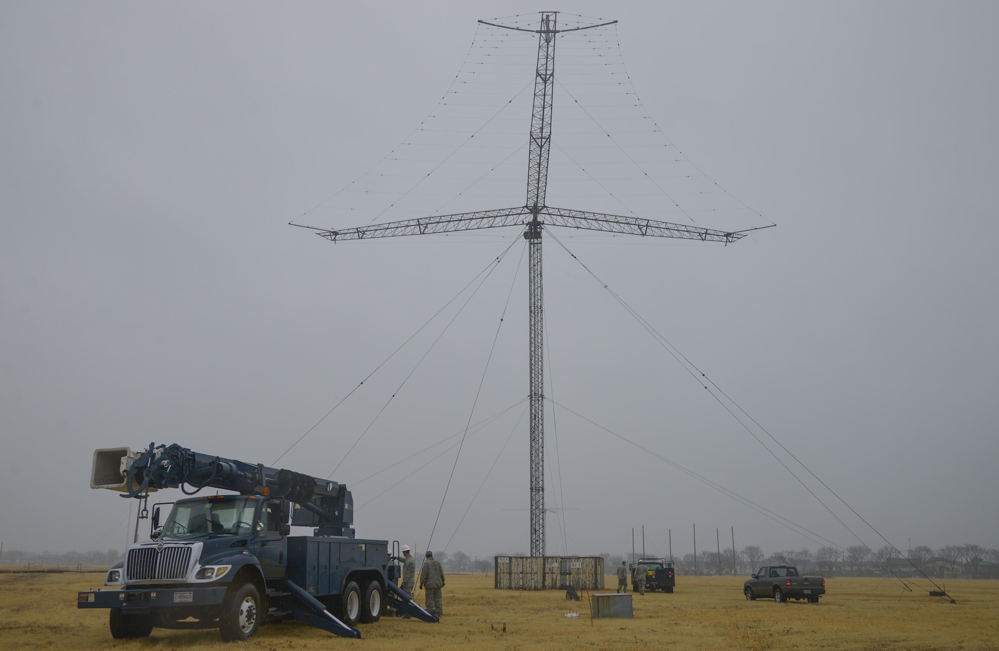 Members of the 374th Communication Squadron Cable and Antenna System Unit set up their trucks prior to taking down a rotatable log periodic antenna at the Tokorozawa Communication Site, Japan, March 14, 2017. Removing the antenna will allow a road to be placed through the site for emergency vehicles to have a quicker response time. (U.S. Air Force photo by Staff Sgt. David Owsianka)