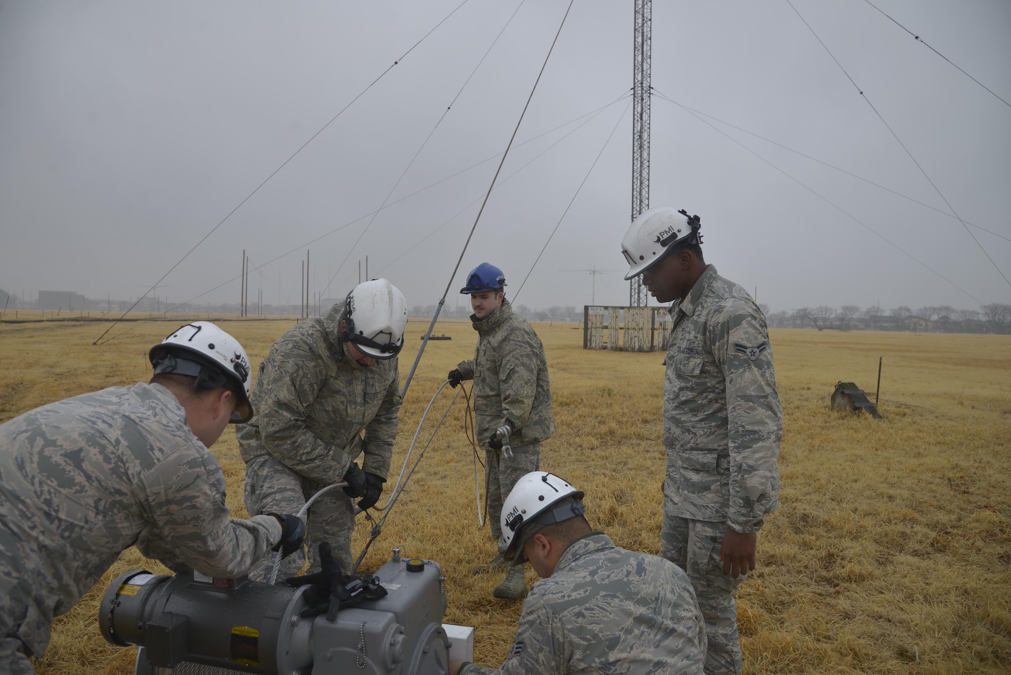 Members of the 374th Communication Squadron Cable and Antenna System Unit set up the winch line at the Tokorozawa Communication Site, Japan, March 14, 2017. The Airmen took the rotatable log periodic antenna down over a three day period to allow a road to be placed through the site for emergency vehicles to have a quicker response time. (U.S. Air Force photo by Staff Sgt. David Owsianka)