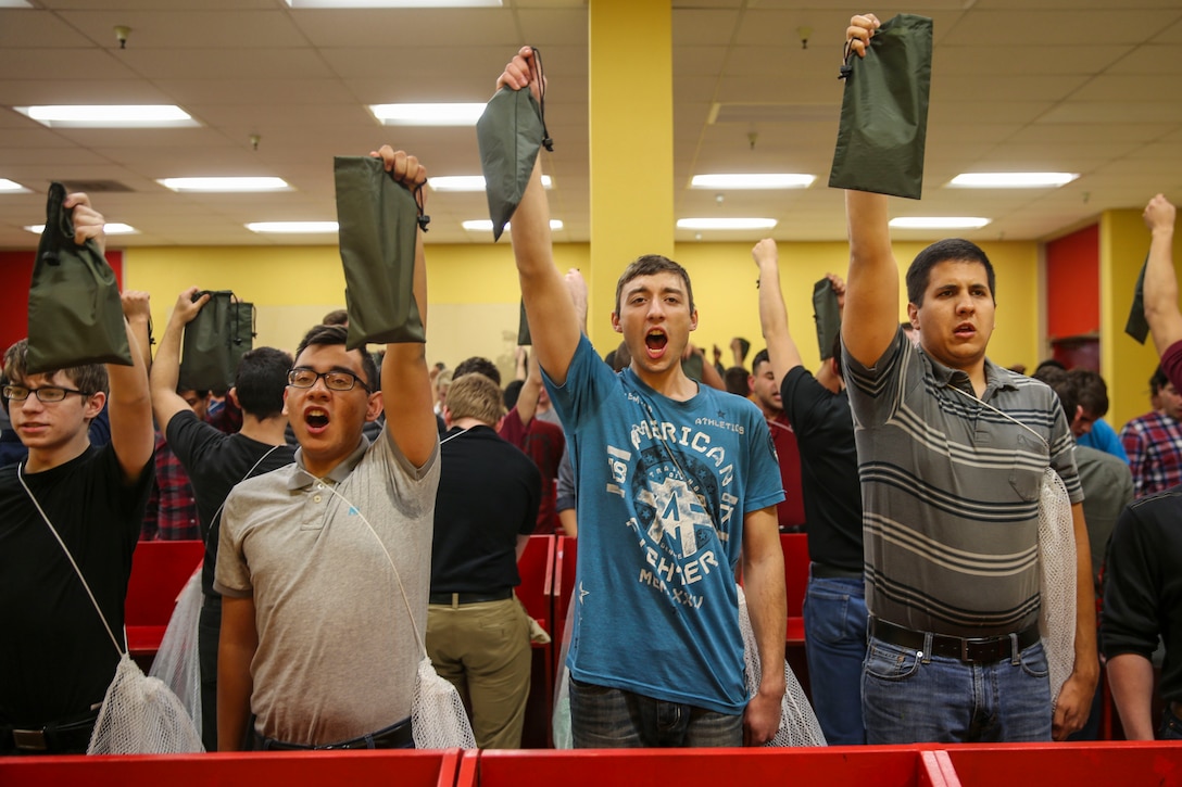 Recruits from Bravo Company, 1st Recruit Training Battalion, hold up their money valuable bags during receiving at Marine Corps Recruit Depot San Diego, March 6. Recruits are required to place any valuable items such as credit cards, driver’s licenses, or cash into the bag before training. Annually, more than 17,000 males recruited from the Western Recruiting Region are trained at MCRD San Diego. Bravo Company is scheduled to graduate June 2.