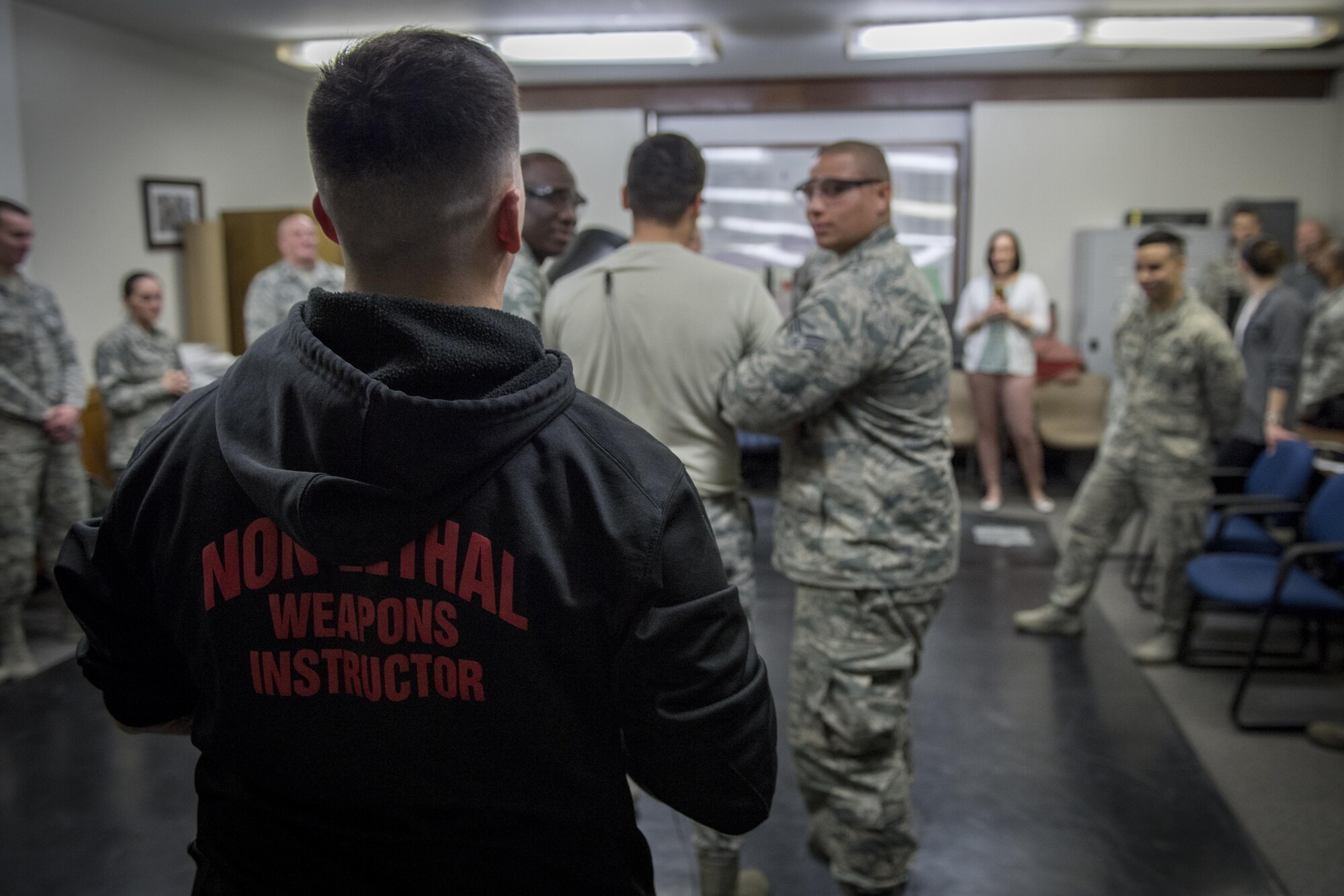 Tech. Sgt. Justin McDonald, 374th Security Forces Squadron NCO in charge of security forces training, counts down to tase an Airmen during a less-lethal weapons demonstration, March 15, 2017, at Yokota Air Base, Japan. McDonald is one of two SFS members to attend the Inter-service Nonlethal Individual Weapons Instructor Course. (U.S. Air Force photo by Airman 1st Class Donald Hudson)