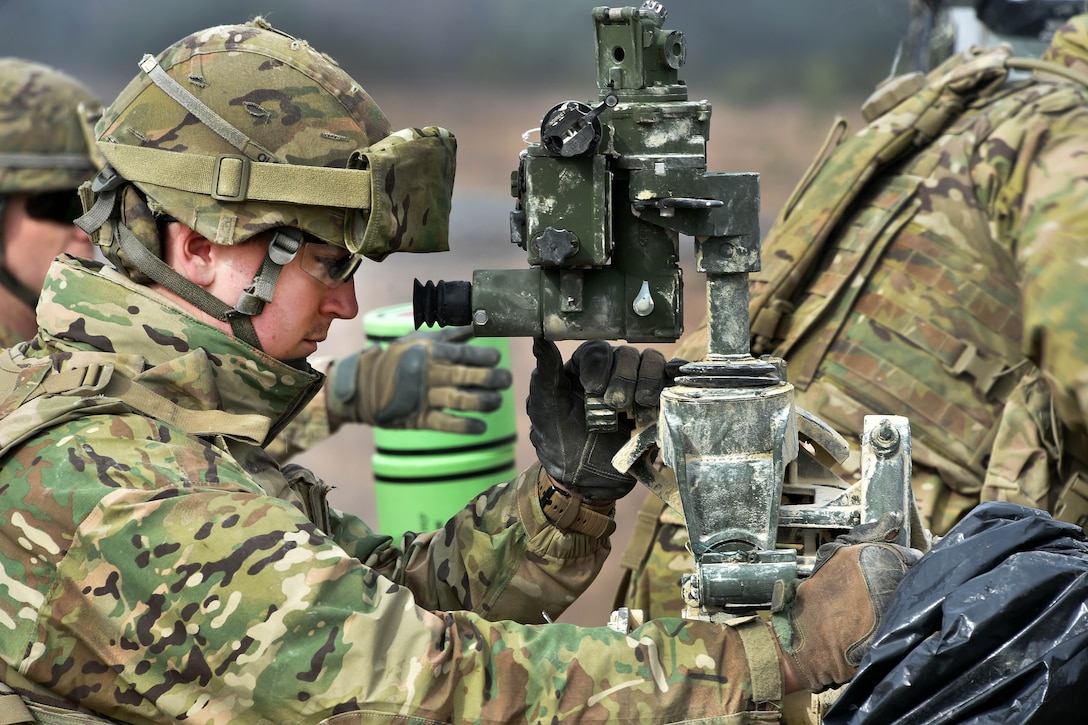 A soldier looks through an M777 howitzer gun sight to acquire distance during exercise Dynamic Front II at the 7th Army Training Command's Grafenwoehr Training Area, Germany, March 9, 2017. Army photo by Gertrud Zach 