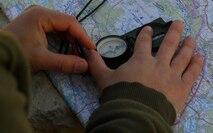 A Turkish student of the U.S. Air Forces in Europe Air-Ground Operations School’s Joint Terminal Attack Controller Qualification Course looks at a compass to determine the location of a target during the live-fire portion of the training at Grafenwoehr Training Area, Germany, March 14, 2017. During this portion of the five-week course, students directed pilots to a target for a live drop or dry pass. (U.S Air Force photo by Senior Airman Tryphena Mayhugh)