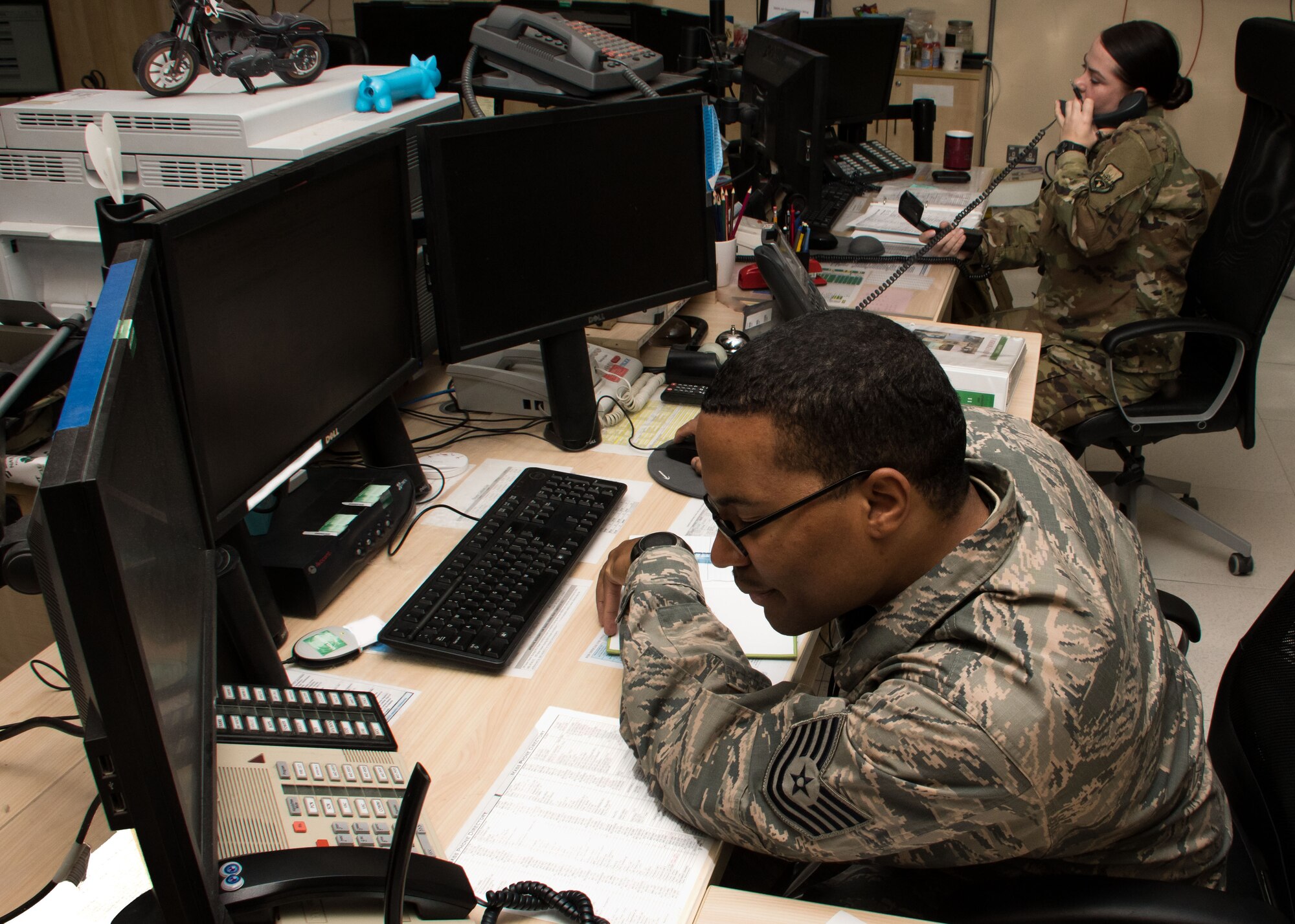 Tech. Sgt. Jeremy Barber, 386th Air Expeditionary Wing command and control systems NCO in charge, and Senior Airman Laurin Curtis, a 386th AEW emergency action controller, work at consoles in the command post March 15, 2017. Command post personnel are trained and certified to handle a vast array of situations, which can include monitoring flights and aircraft maintenance as well as passenger and cargo movement. (U.S. Air Force photo illustration/Senior Airman Andrew Park)  