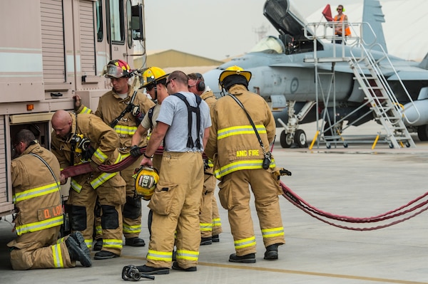 U.S. Air Force 380th Expeditionary Civil Engineer Squadron firefighters and Royal Australian Air Force firefighters store equipment on a firetruck after completing a Coalition training exercise at an undisclosed location in Southwest Asia, March 16, 2017. USAF and RAAF firefighters have completed weekly exercises for nearly three months while supporting Operation Inherent Resolve. The training scenarios have developed critical firefighting fundamentals required during deployed day-to-day operations. (U.S. Air Force photo/Senior Airman Tyler Woodward)