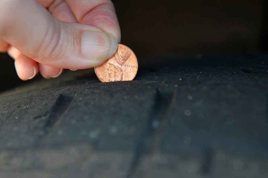 Master Sgt. Melissa Cadle, 86th AW occupational safety manager, uses the “penny test” to inspect the thickness of a tire tread. According to the procedure, if the top of the head in the coin is showing, then the tires need to be replaced. (U.S. Air Force photo by Airman 1st Class Joshua Magbanua)