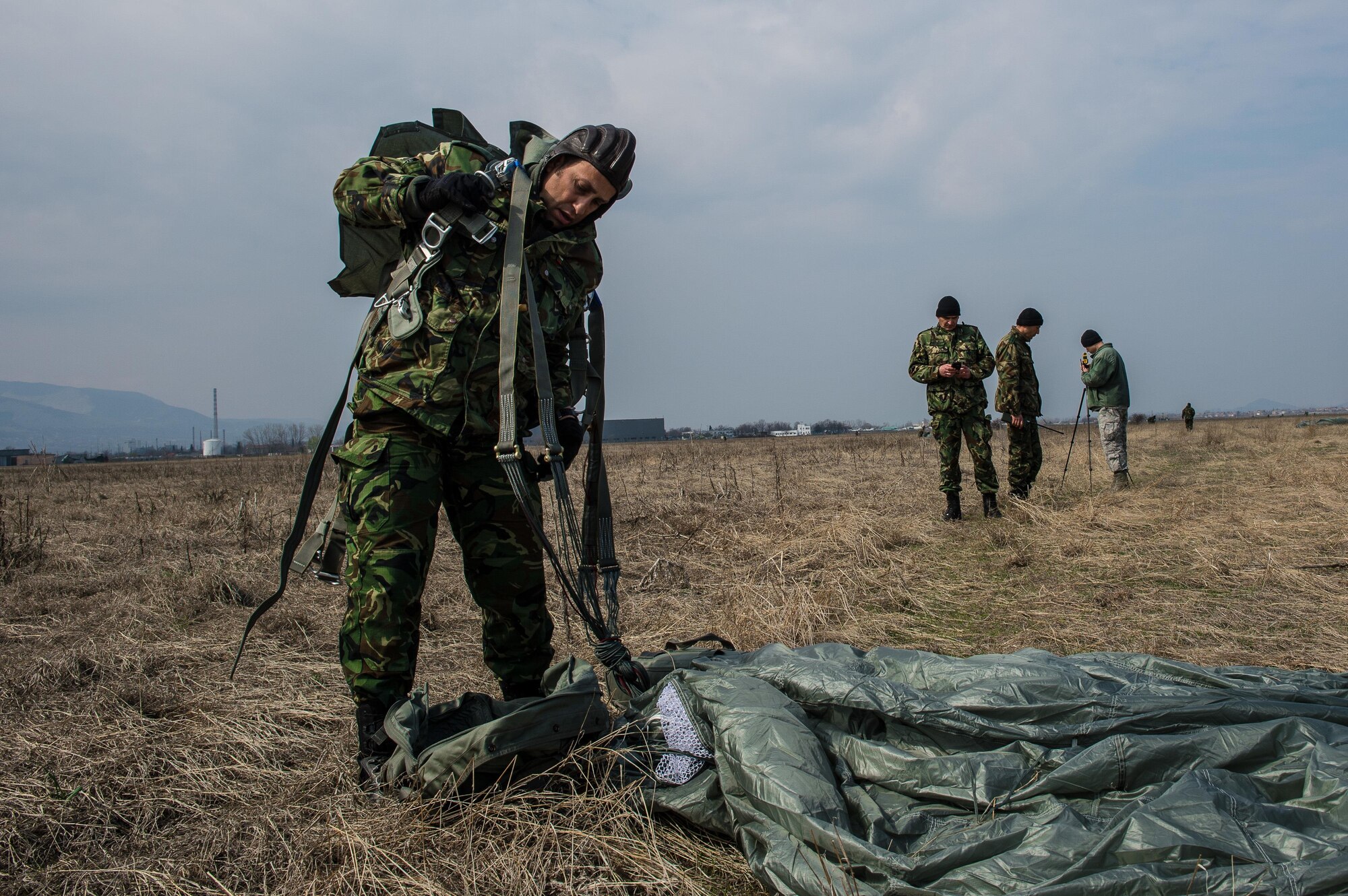 A Bulgarian military paratrooper removes his parachute at the drop zone during Exercise Thracian Spring 17 at Plovdiv Regional Airport, Bulgaria, March 15, 2017. Drop zones are thoroughly surveyed in advance and inspected before every drop in to order to ensure a safe landing for personnel or cargo.  More than 60 U.S. Air Force Airmen from Ramstein Air Base, Germany, participated in combined air operations with the Bulgarian military to strengthen relationships while building their nations’ joint military capabilities.  (U.S. Air Force photo by Staff Sgt. Nesha Humes)