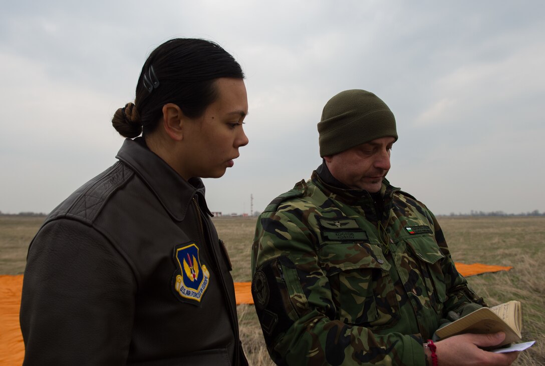 Capt. Mary Bordelon, 37th Airlift Squadron flight commander and Exercise Thracian Spring 17 mission commander talks with Master Sgt. Momchil Kostov, Bulgarian Special Operations 1st Battalion, 68th Brigade special warfare personnel at Plovdiv Regional Airport, Bulgaria, March 15, 2017.  Bordelon visited the drop zone team to watch the team execute the first personnel drop for the two-week exercise. The U.S. Air Force’s forward presence in Europe allows Airmen to work with our Nato Allies and partners, to develop ready air forces capable of maintaining regional security. (U.S. Air Force photo by Staff Sgt. Nesha Humes)