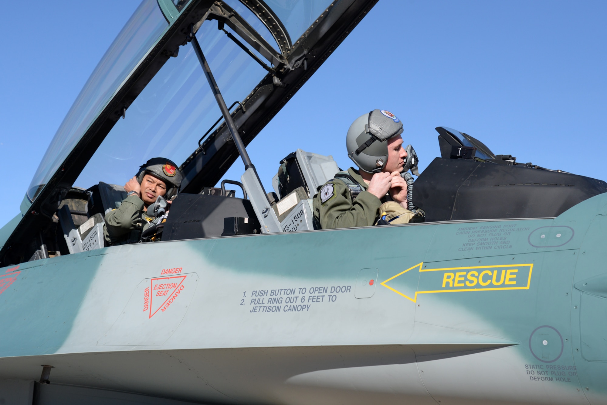 U.S. Air Force pilot, Capt. Sean Rush (front) and Indonesian Air Force pilot, Maj. Gusti Made Yoga Ambara (rear), strap on thier helmets at Hill Air Force Base, Utah on March 14 in preparation for the long transoceanic flight to Indonesia. The flight is expected to take four days with schedluded stops enroute.  (U.S. Air Force Photo by Alex R. Lloyd)